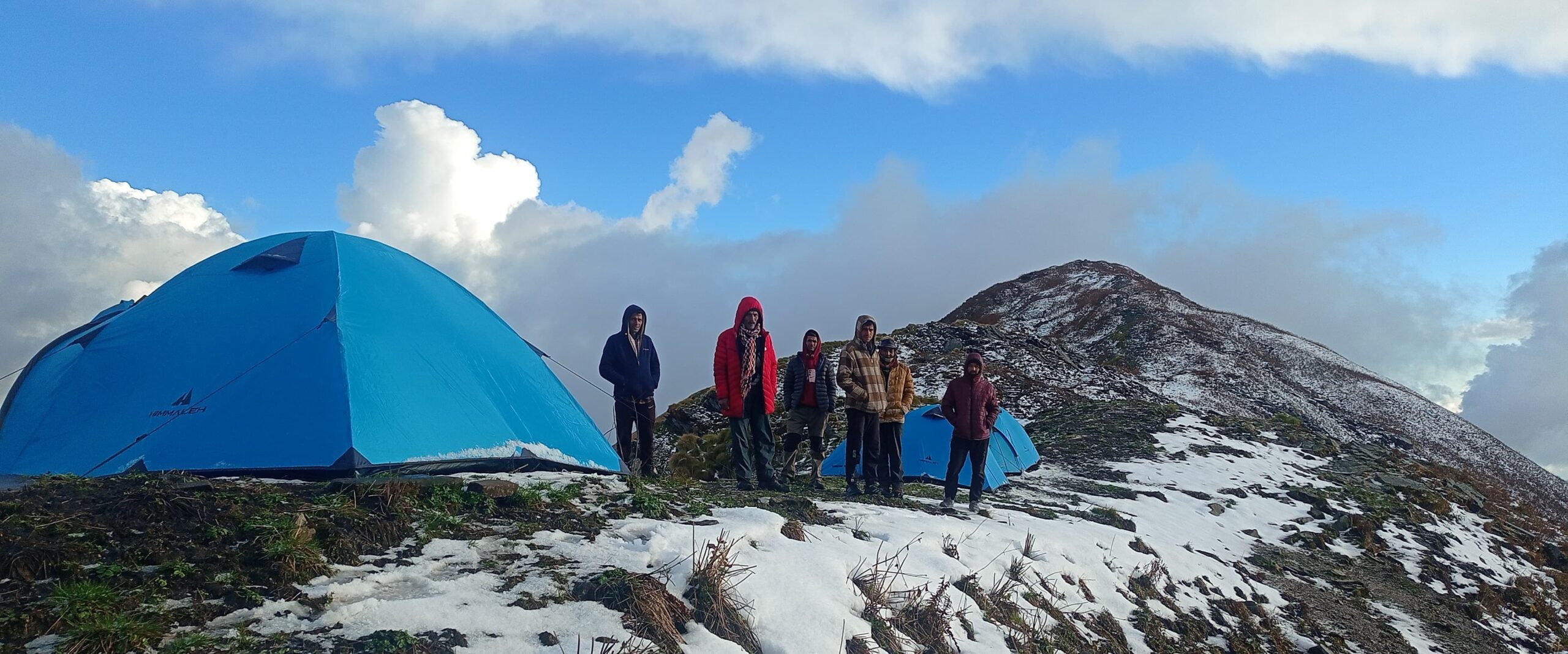 Professional trekking tents pitched at Chofu Top campsite under a clear starlit sky in the Kumaon Himalayas.